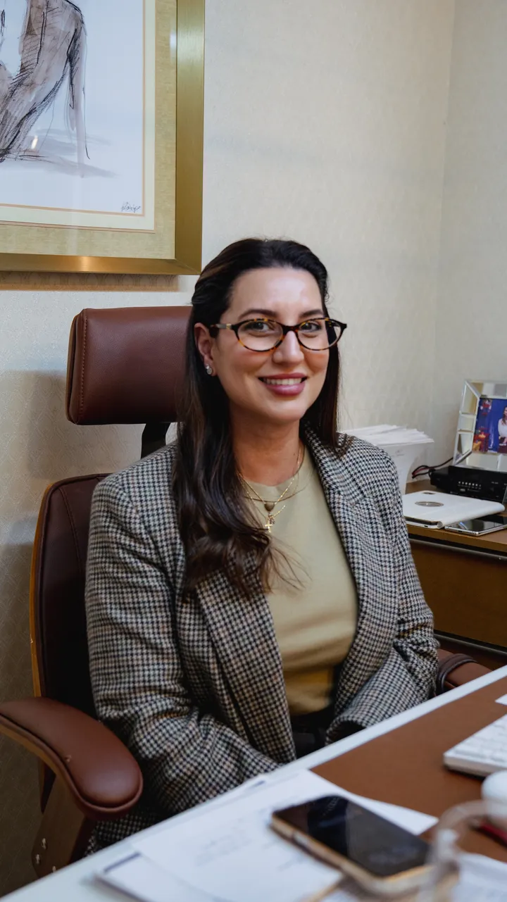 Mariana Ramos sorrindo, sentada em seu consultório